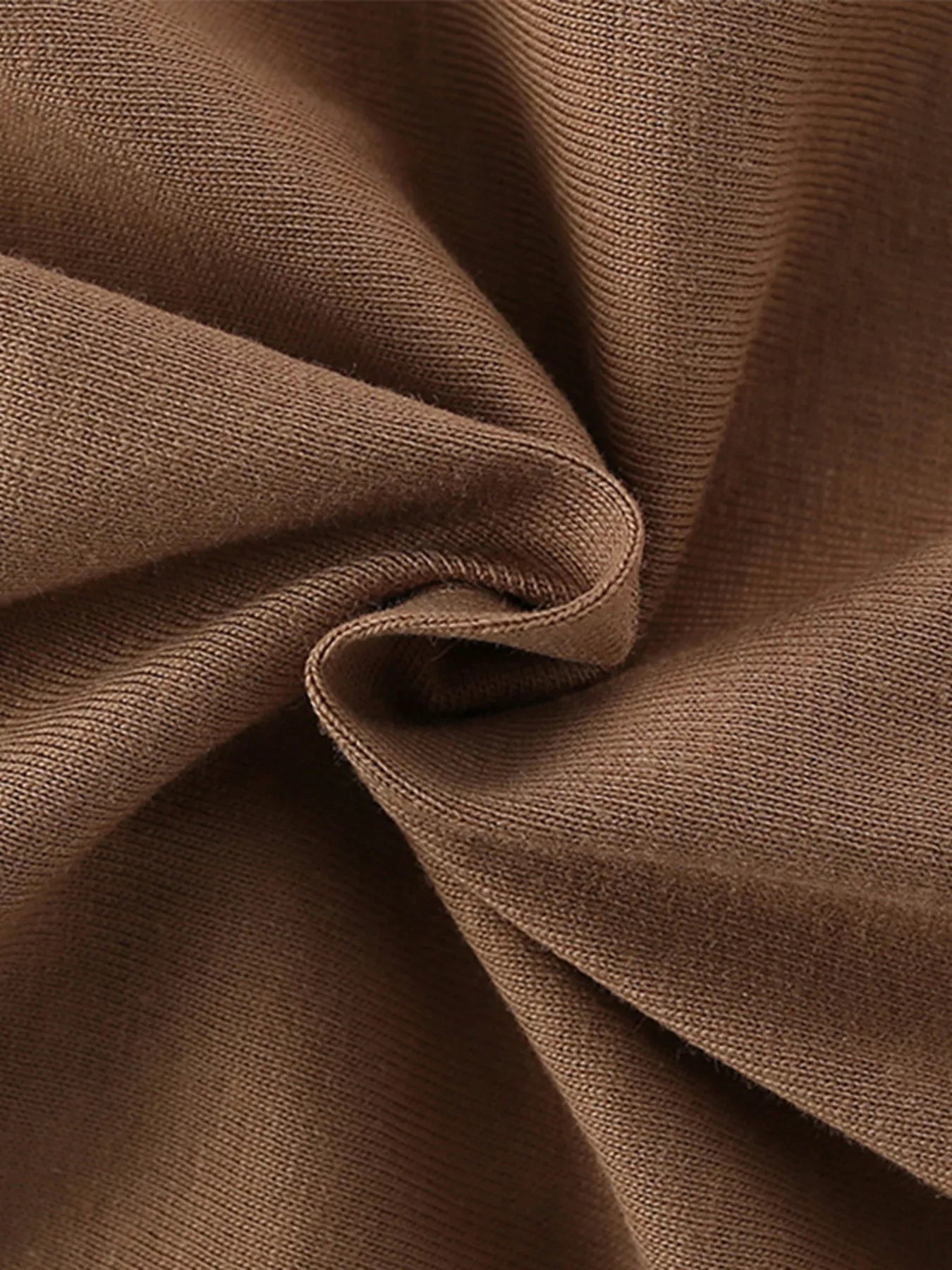 Close-up of soft folded caramel knit fabric texture of children's short sleeve t-shirt