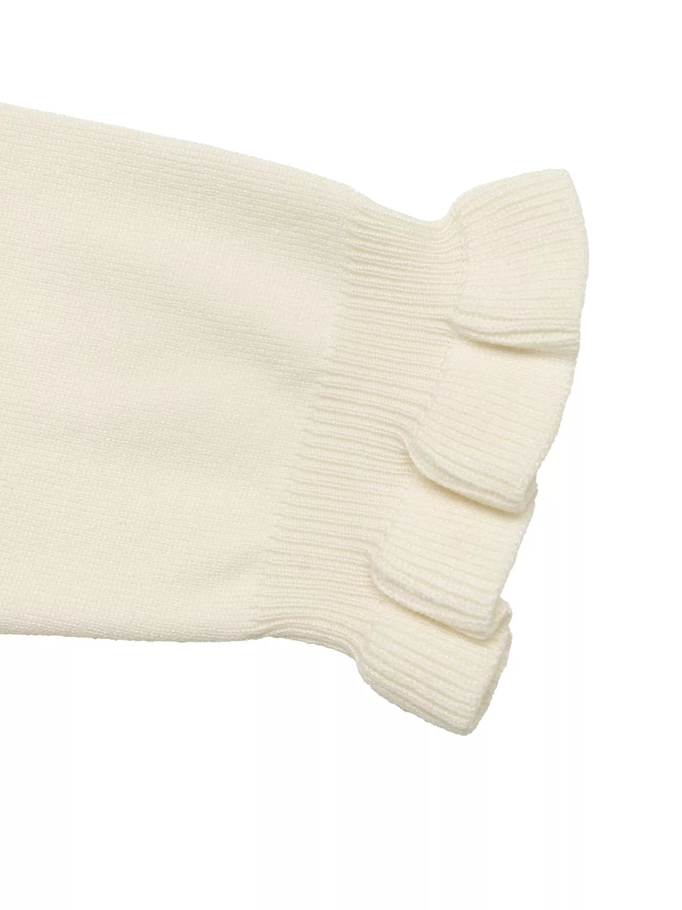 Close up of cream knit top sleeve showing ruffled cuff detail flat lay