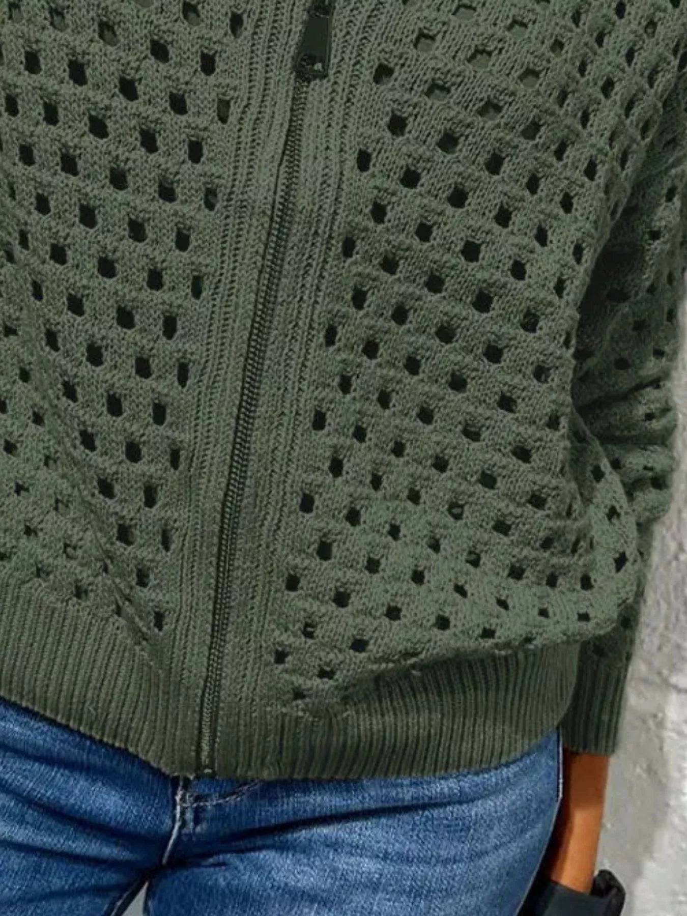 Close up of the army green crochet cardigan lower zip and ribbed hem