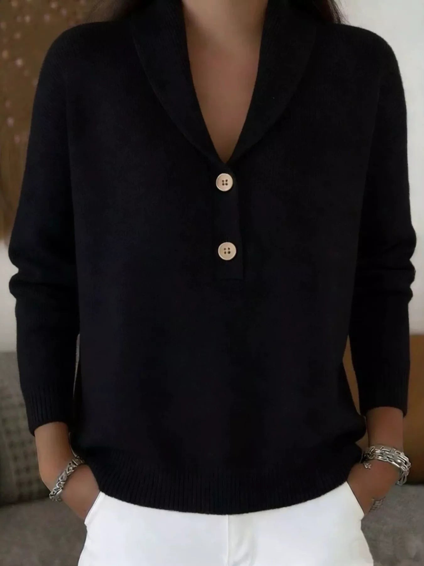 On-model front view of a black shawl collar sweater with cream buttons