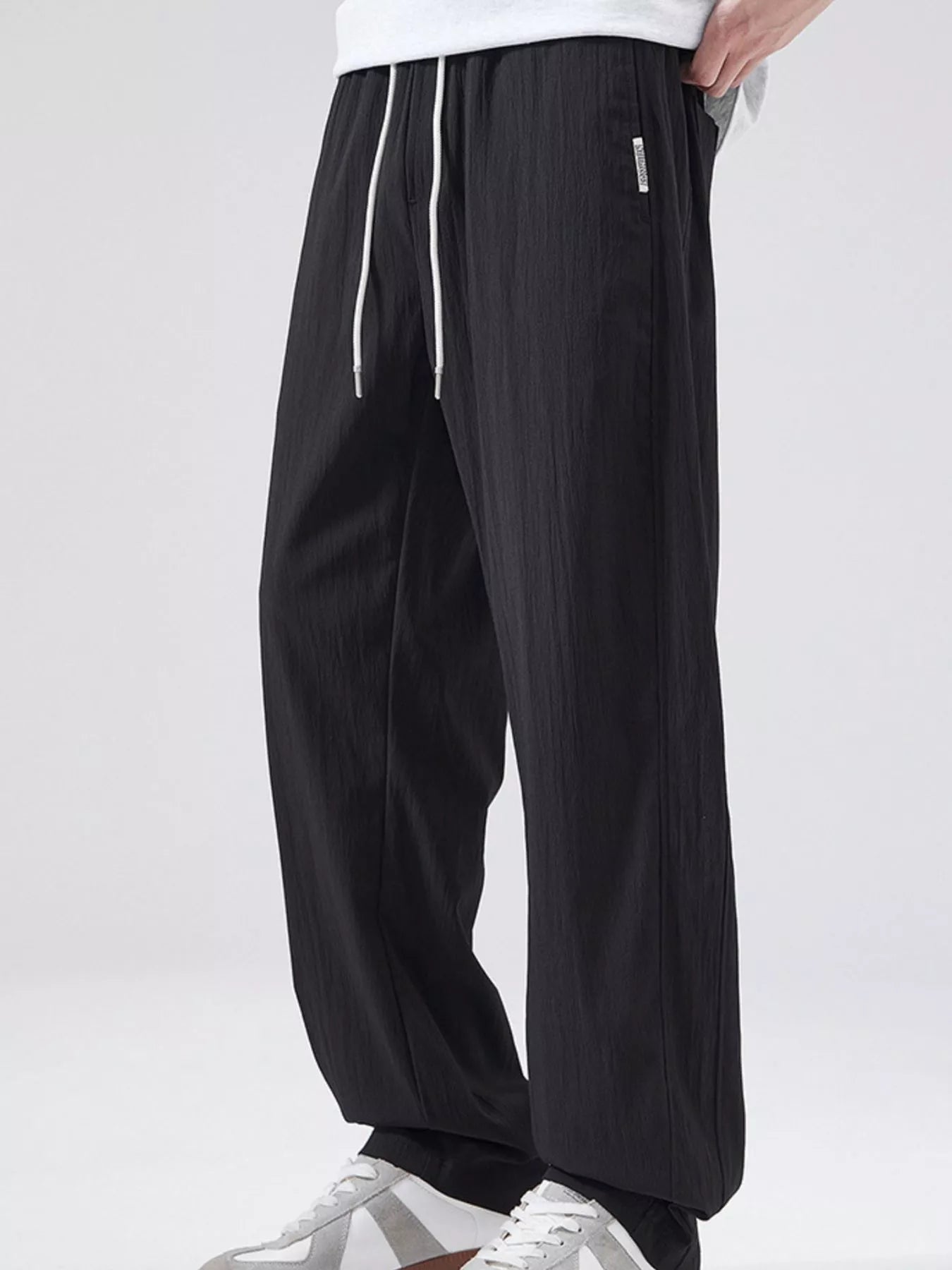Men's black casual wide leg pants with a drawstring waist.