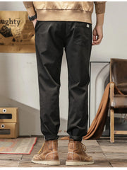 Men's slim fit casual pants with banded ankles and pockets.