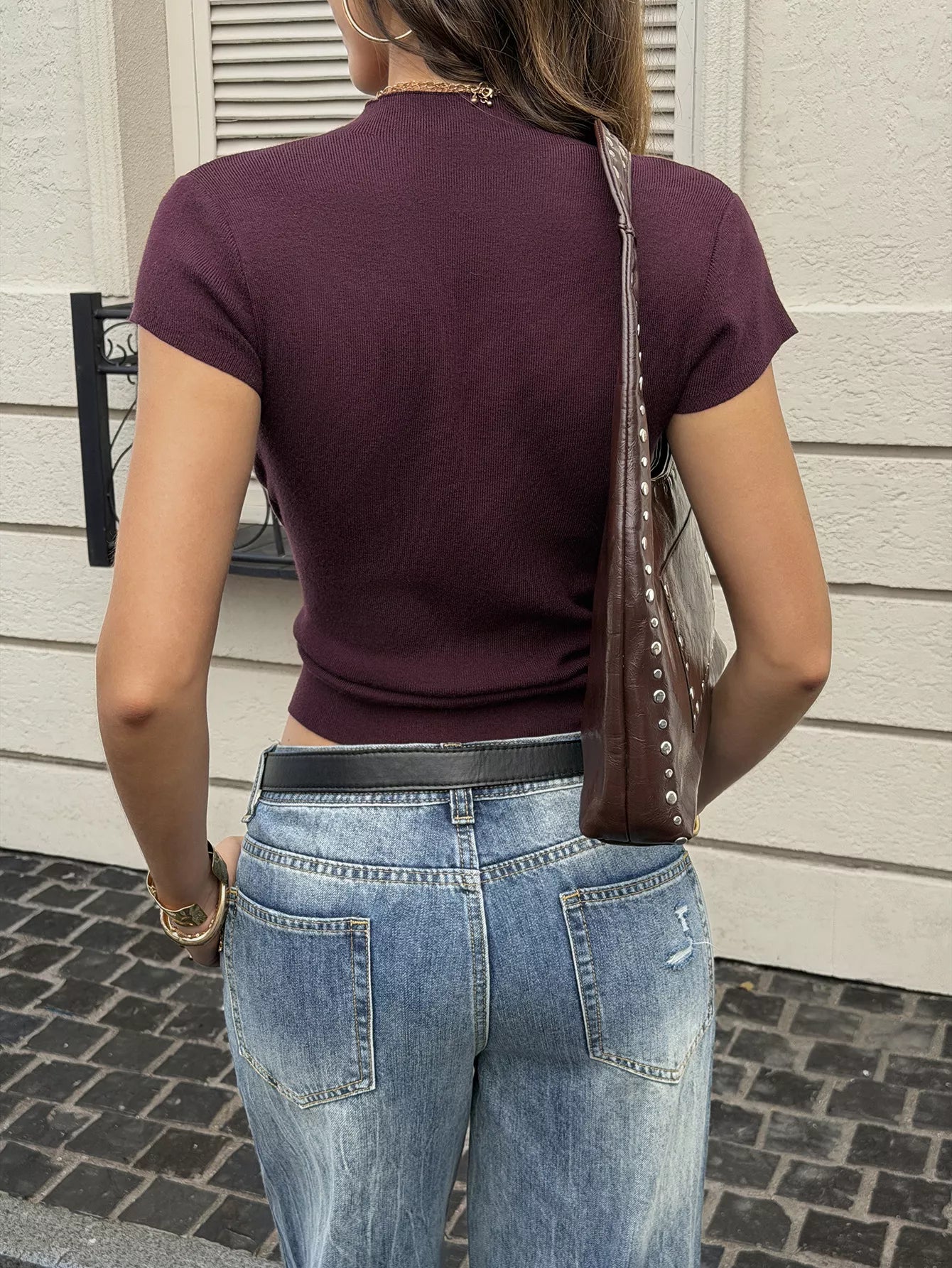 Back view of burgundy ribbed short sleeve knit top with light wash jeans