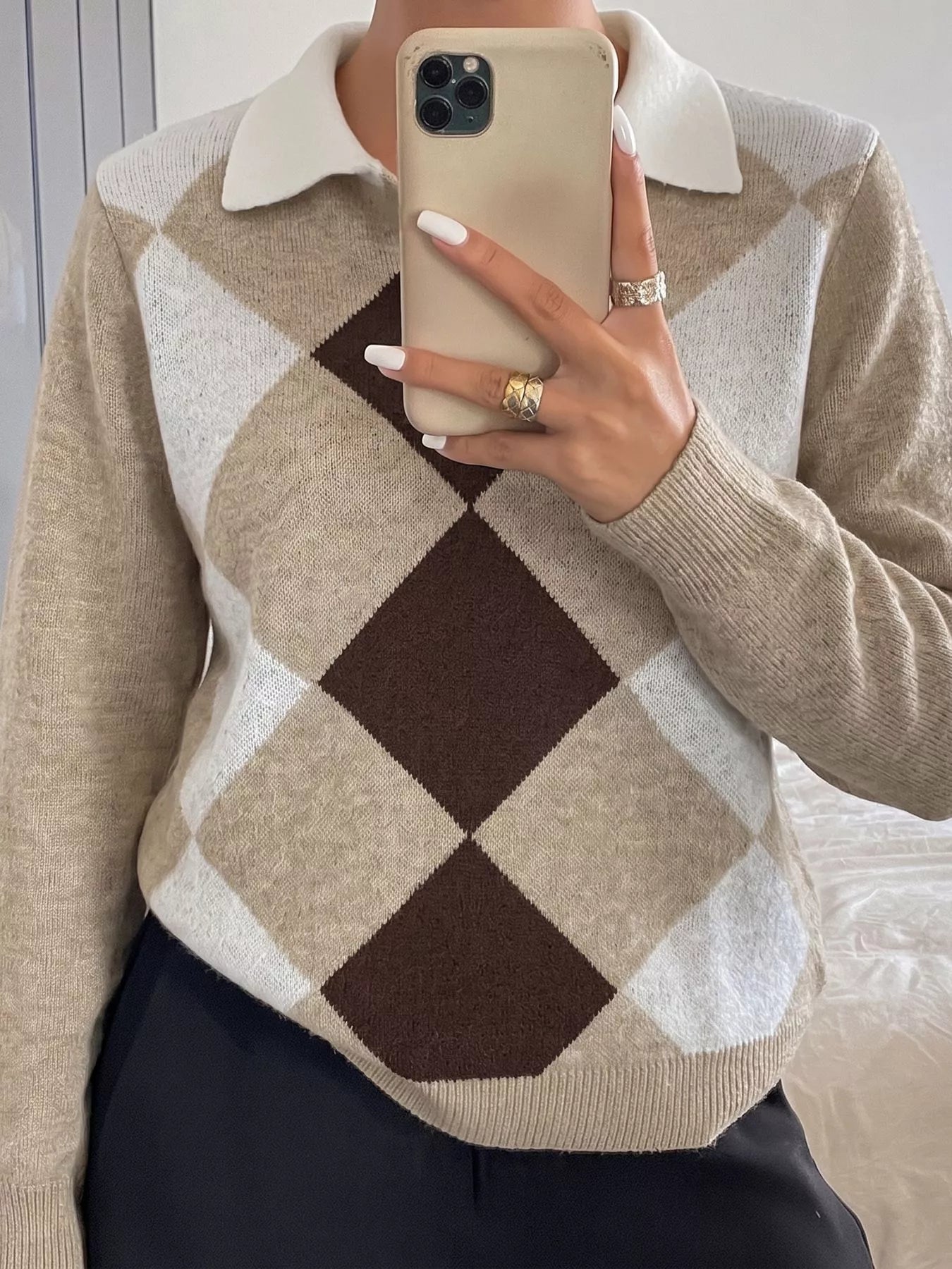 Mirror selfie front view of the argyle polo sweater showing the button placket and collar