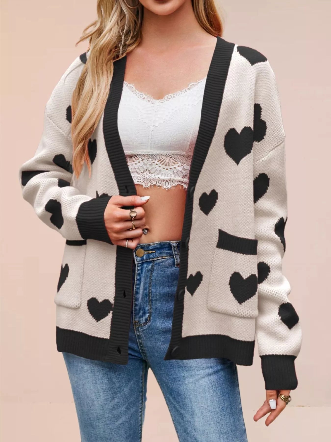 Cream knit cardigan with black hearts and black trim worn open