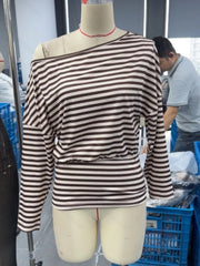 Front view of coffee brown and cream striped one shoulder long sleeve top on mannequin indoors