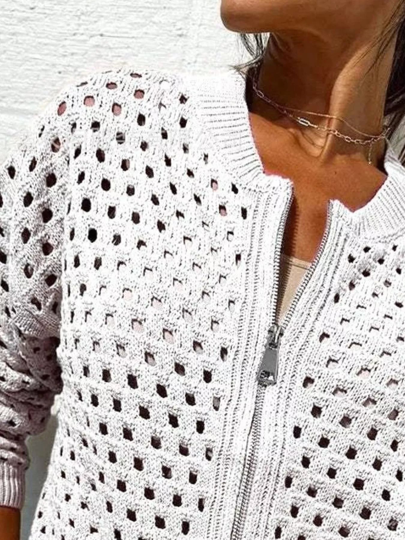 Close up of the white crochet cardigan upper zip and openwork pattern