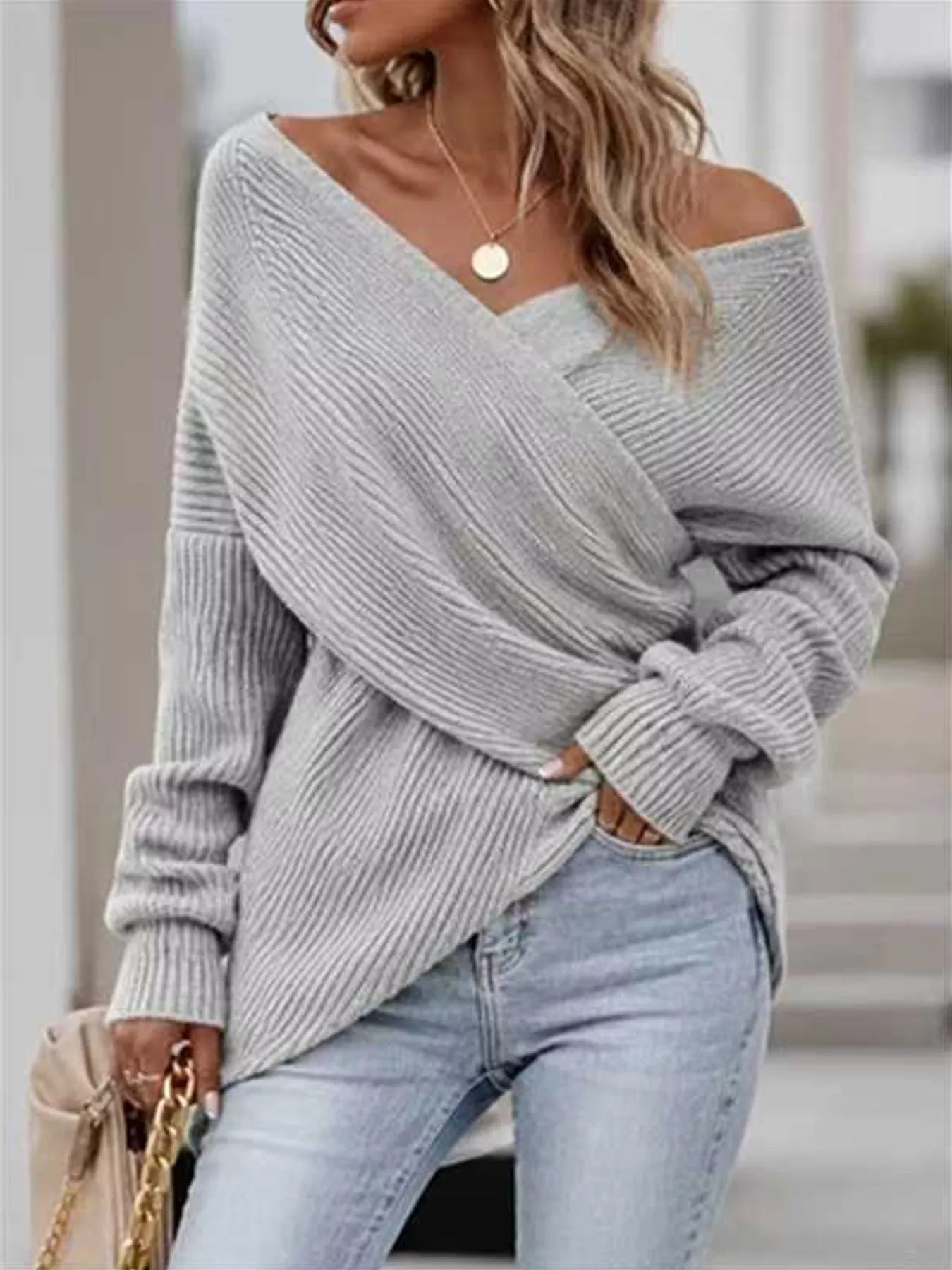 Front view of gray ribbed knit sweater with crisscross V neckline and long sleeves.