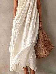 Lower view of a white one shoulder maxi dress showing the flowing skirt and hem