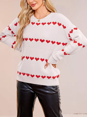 On-model front view of a white dropped shoulder sweater with rows of red hearts