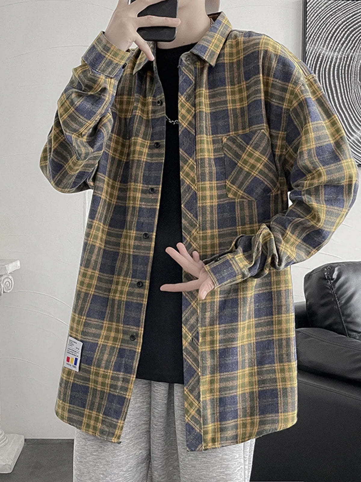 Men's oversized plaid button-up shirt with long sleeves and pockets.