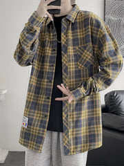 Men's oversized plaid button-up shirt with long sleeves and pockets.