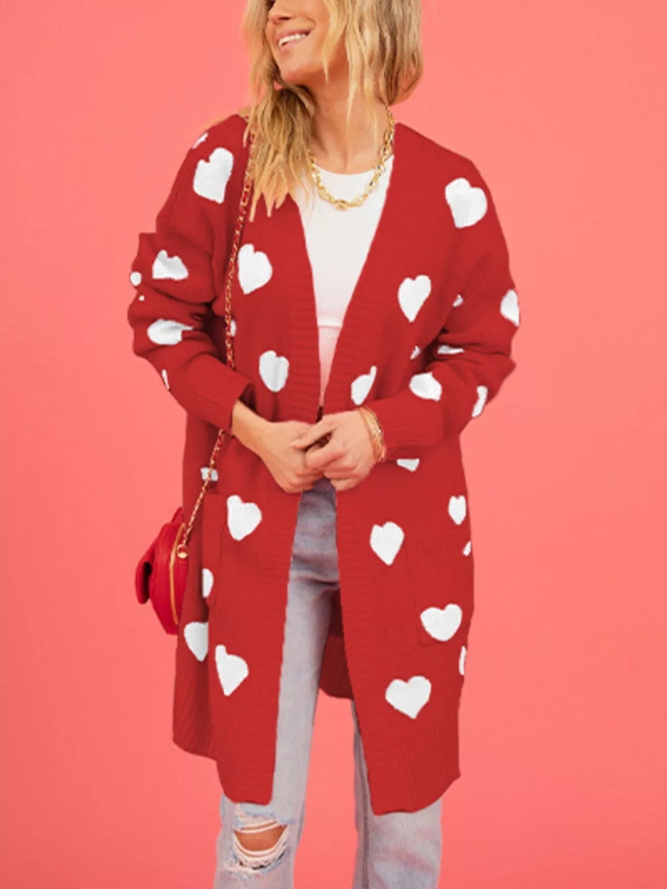 Front view of a red longline cardigan with white hearts worn open