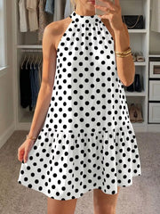 White polka dot halter neck mini dress shown front in a mirror selfie indoors