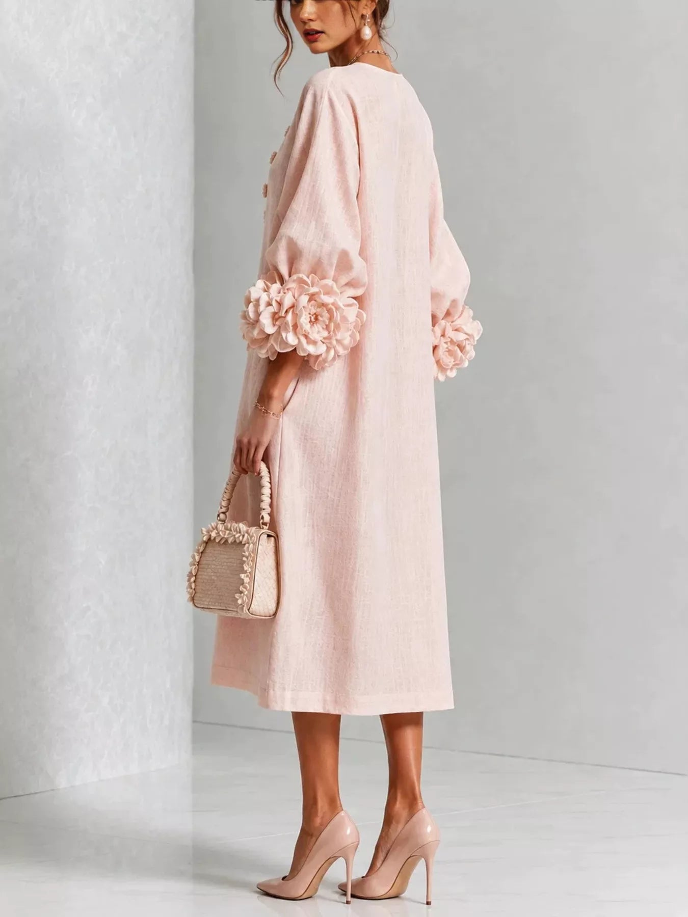 Back view of the watermelon pink round neck midi dress with balloon sleeves and large floral sleeve cuffs