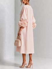 Back view of the watermelon pink round neck midi dress with balloon sleeves and large floral sleeve cuffs