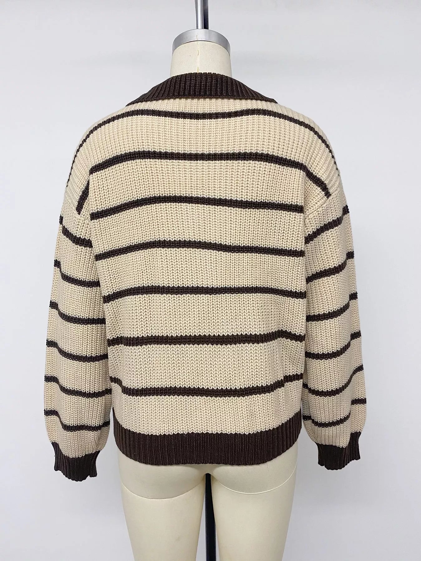 Back view on a mannequin of a cream and brown striped knit polo sweater.