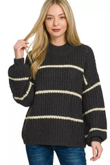 Front view of black oversize striped sweater with cream stripes and dark jeans