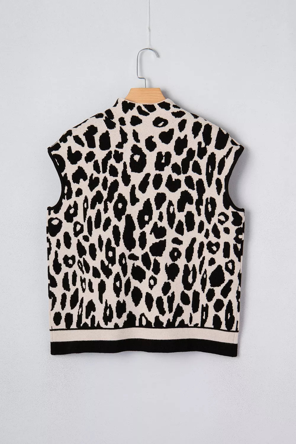 Flat lay back view of the black and cream leopard print high neck sweater on a hanger.
