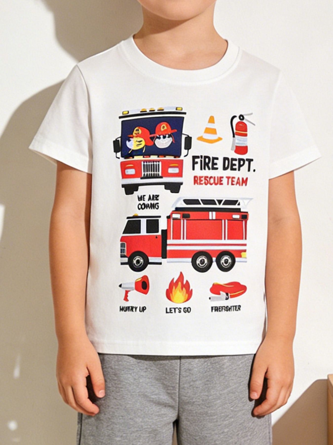 Worn front view of white children's t-shirt with red fire truck rescue graphics