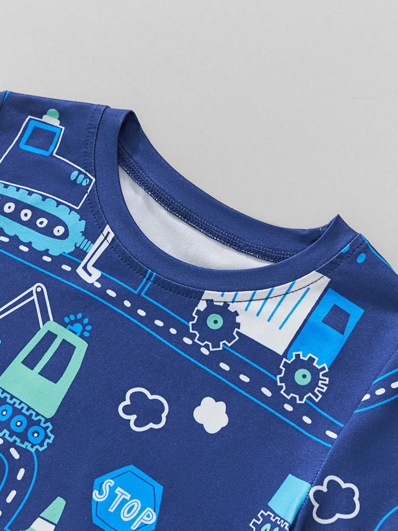 Close-up of the round neckline and stitching on the children's dark blue road print tee