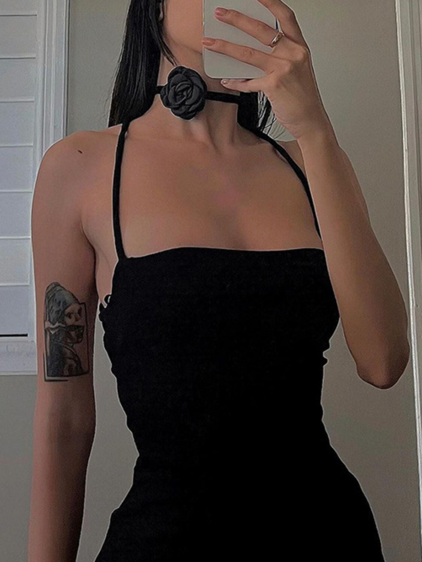 Close up of the black halter neck bodycon dress bodice in a mirror selfie