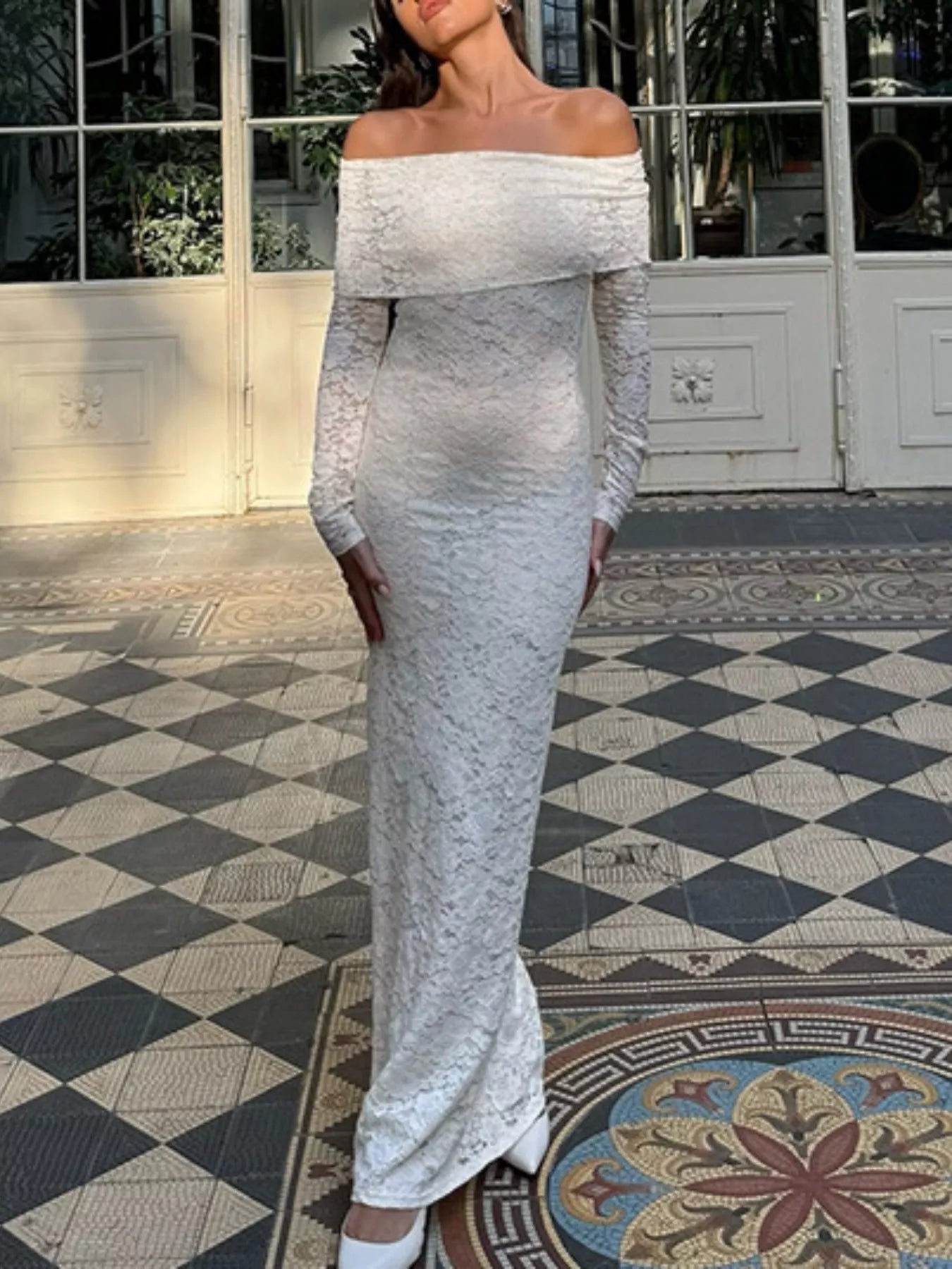 Full length front view of a white off shoulder lace maxi bodycon dress outdoors
