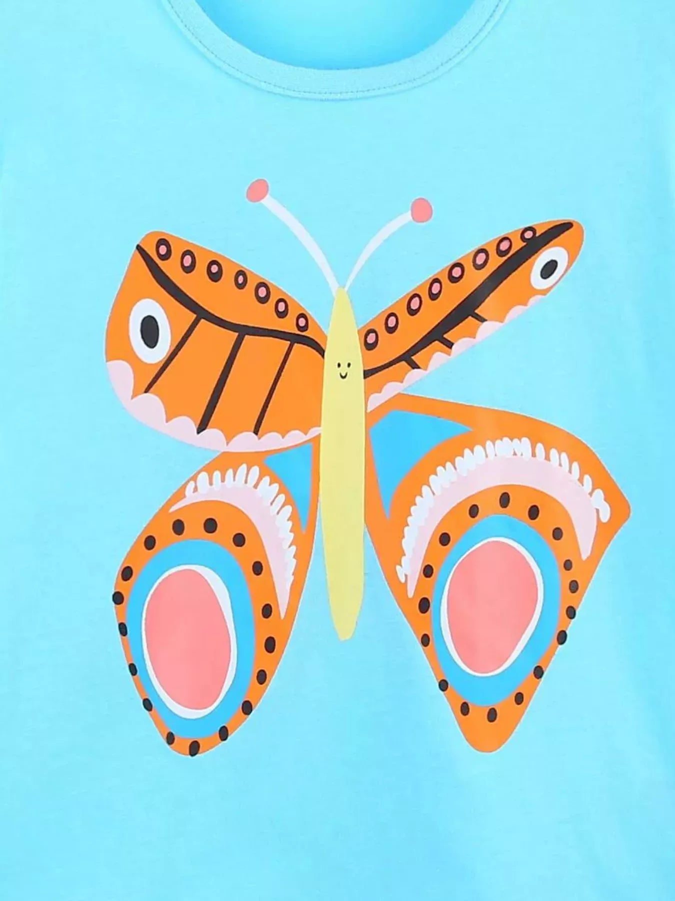 Close-up detail of the orange butterfly graphic with patterned wings on blue fabric