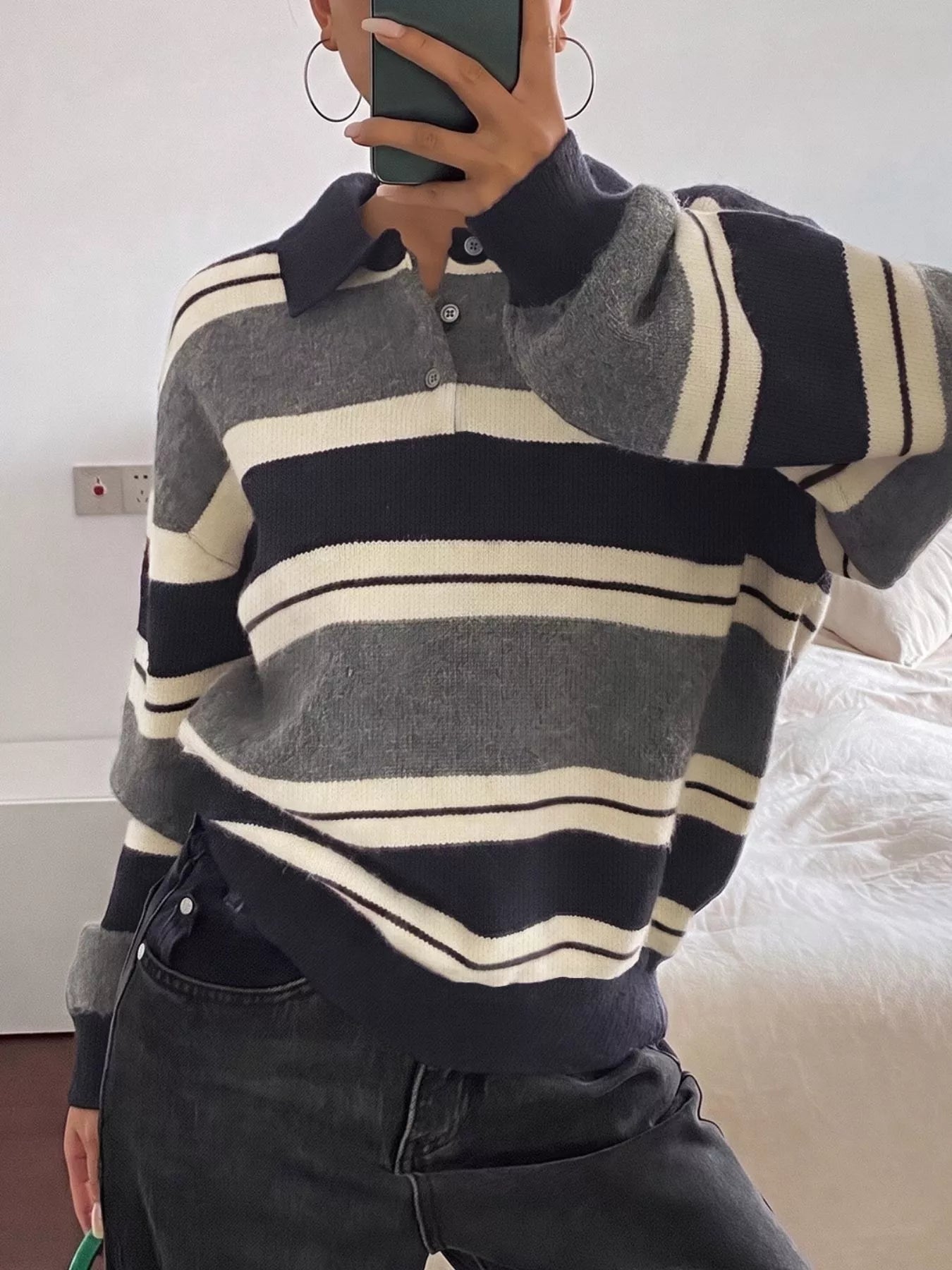 On-model front view of the navy, gray, and cream striped sweater with ribbed cuffs