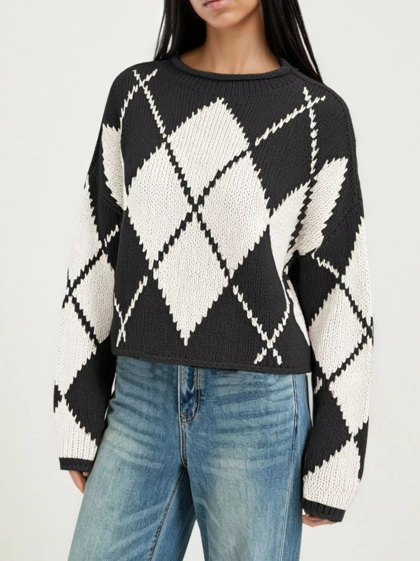 Cropped on-model front view of the black and cream argyle sweater showing the diamond pattern