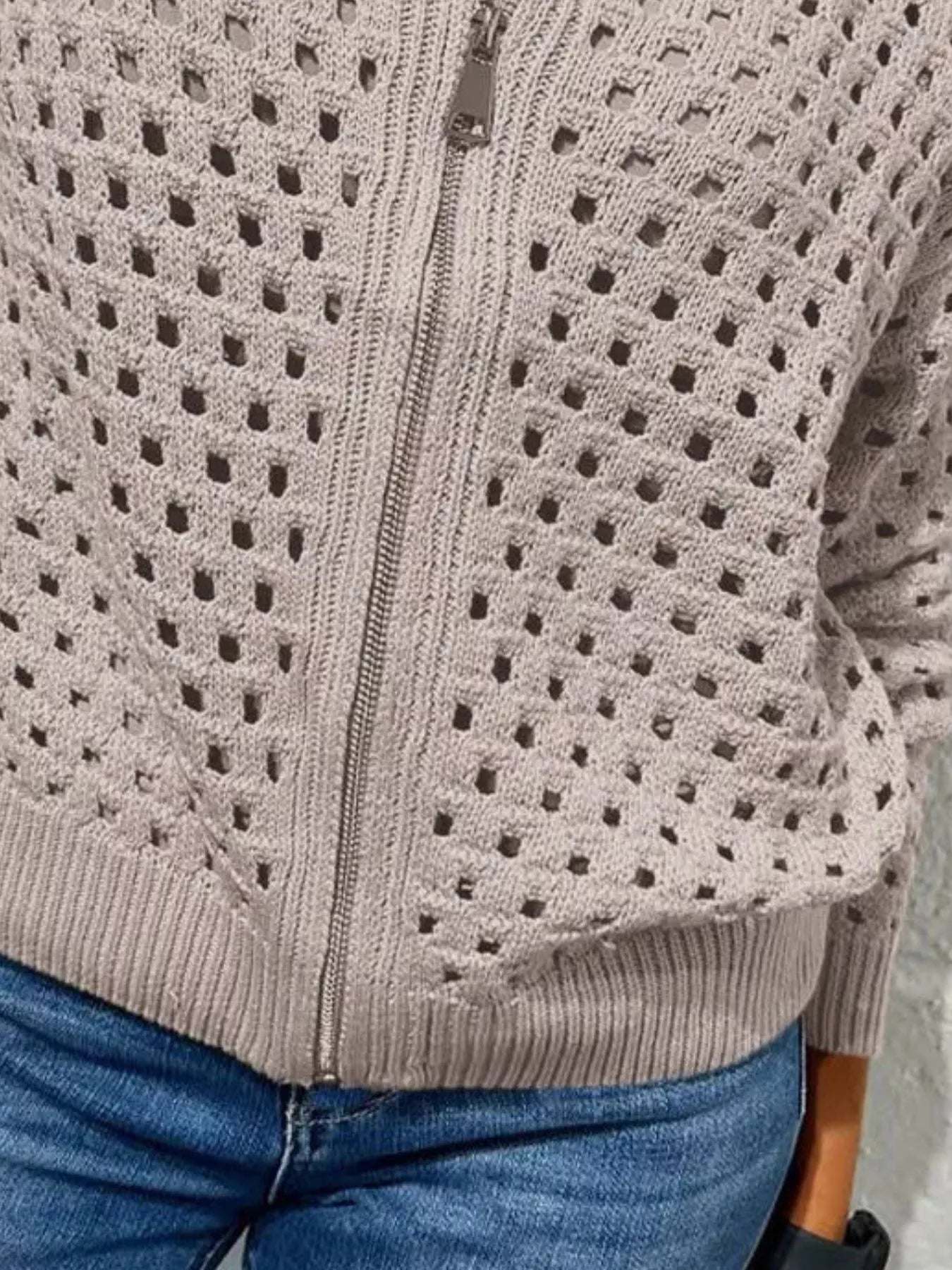 Close up of the light taupe crochet cardigan lower zip and ribbed hem