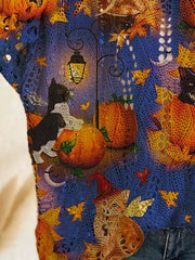 Close up view of the blue openwork knit cover up with cats, pumpkins, and a glowing lantern.