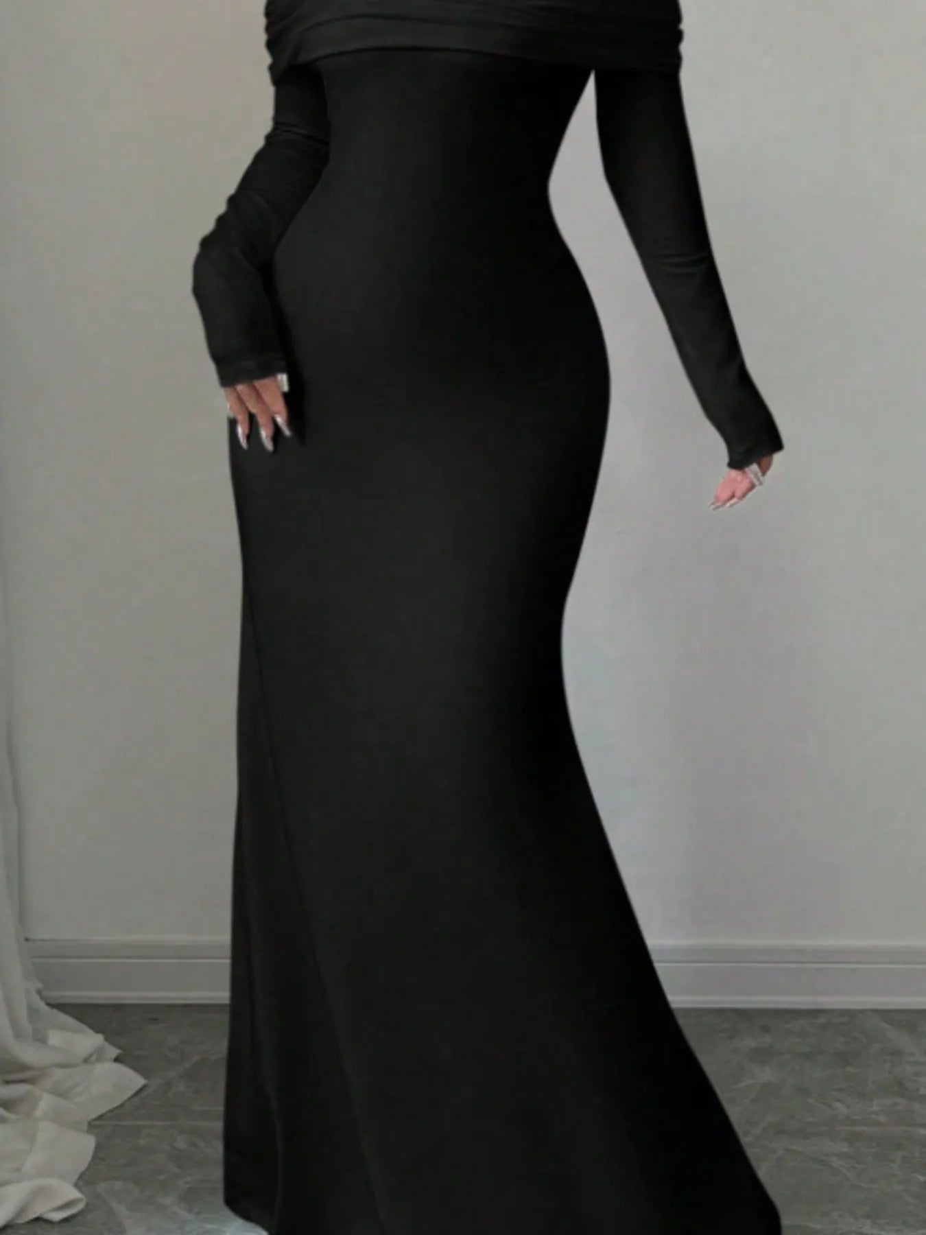 Close view of black off shoulder maxi skirt showing the fitted silhouette to the hem