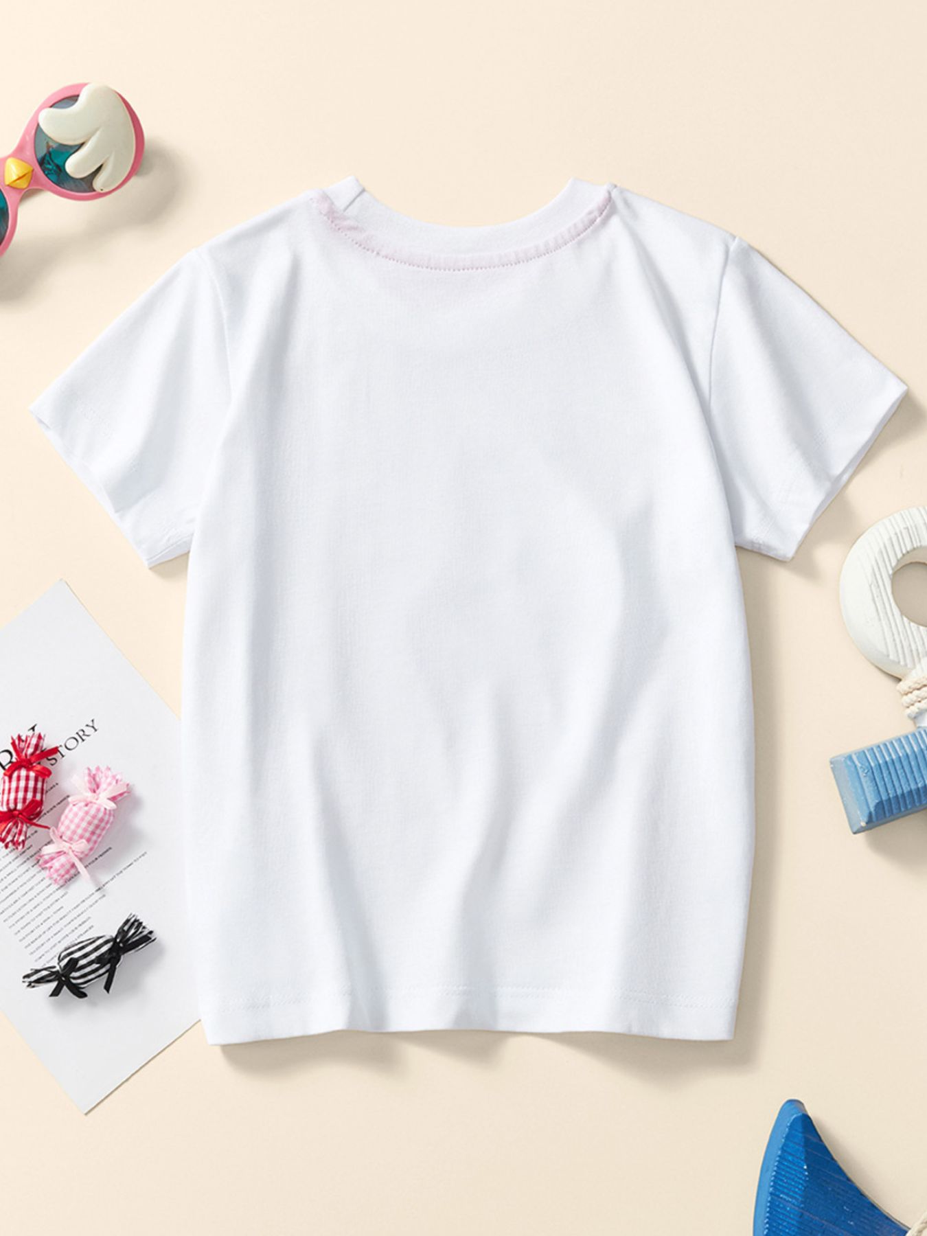 Back view of a plain white children's short sleeve tee laid flat with a round neckline