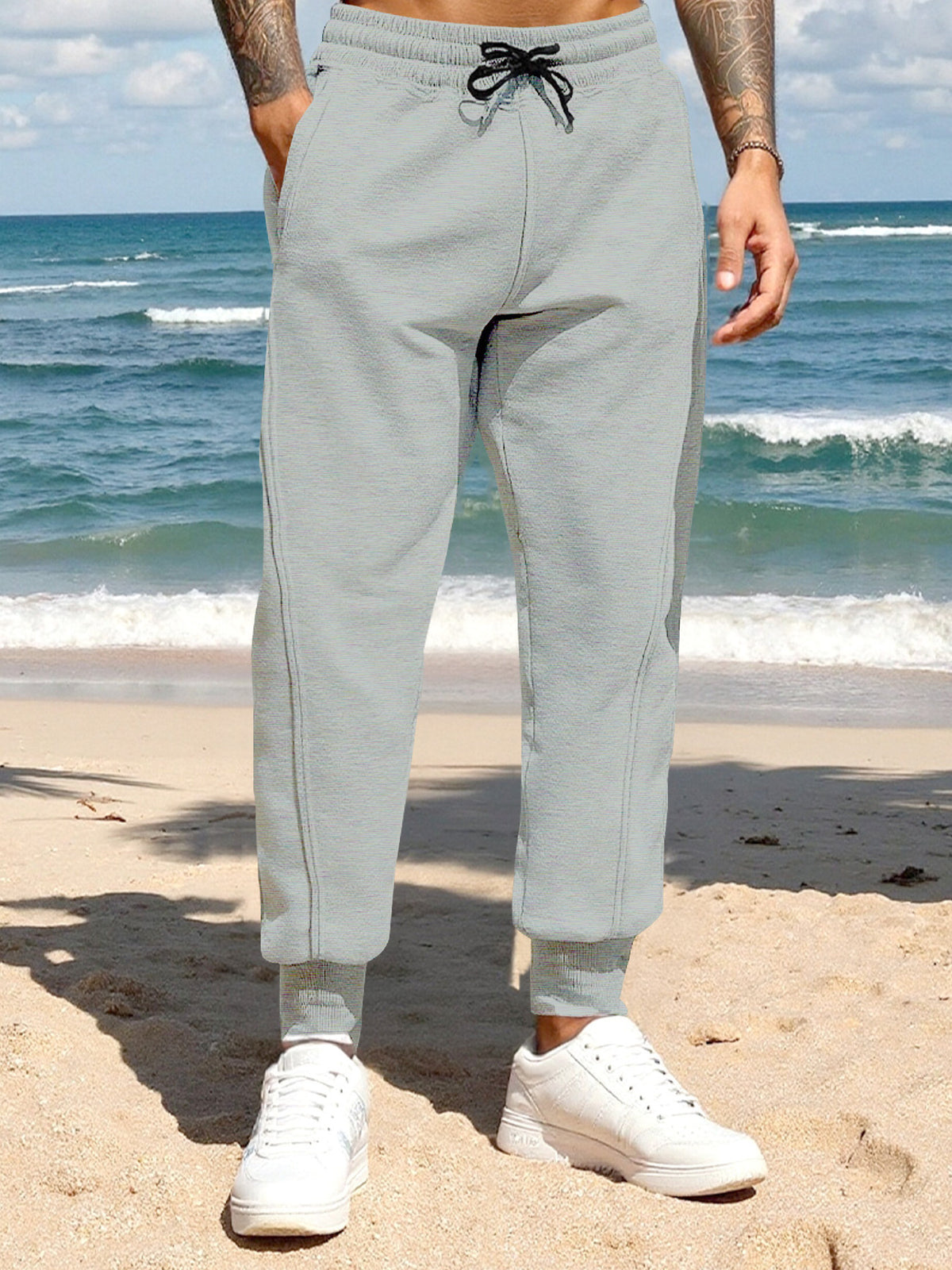 Men's light gray casual joggers with a drawstring waist and pockets.