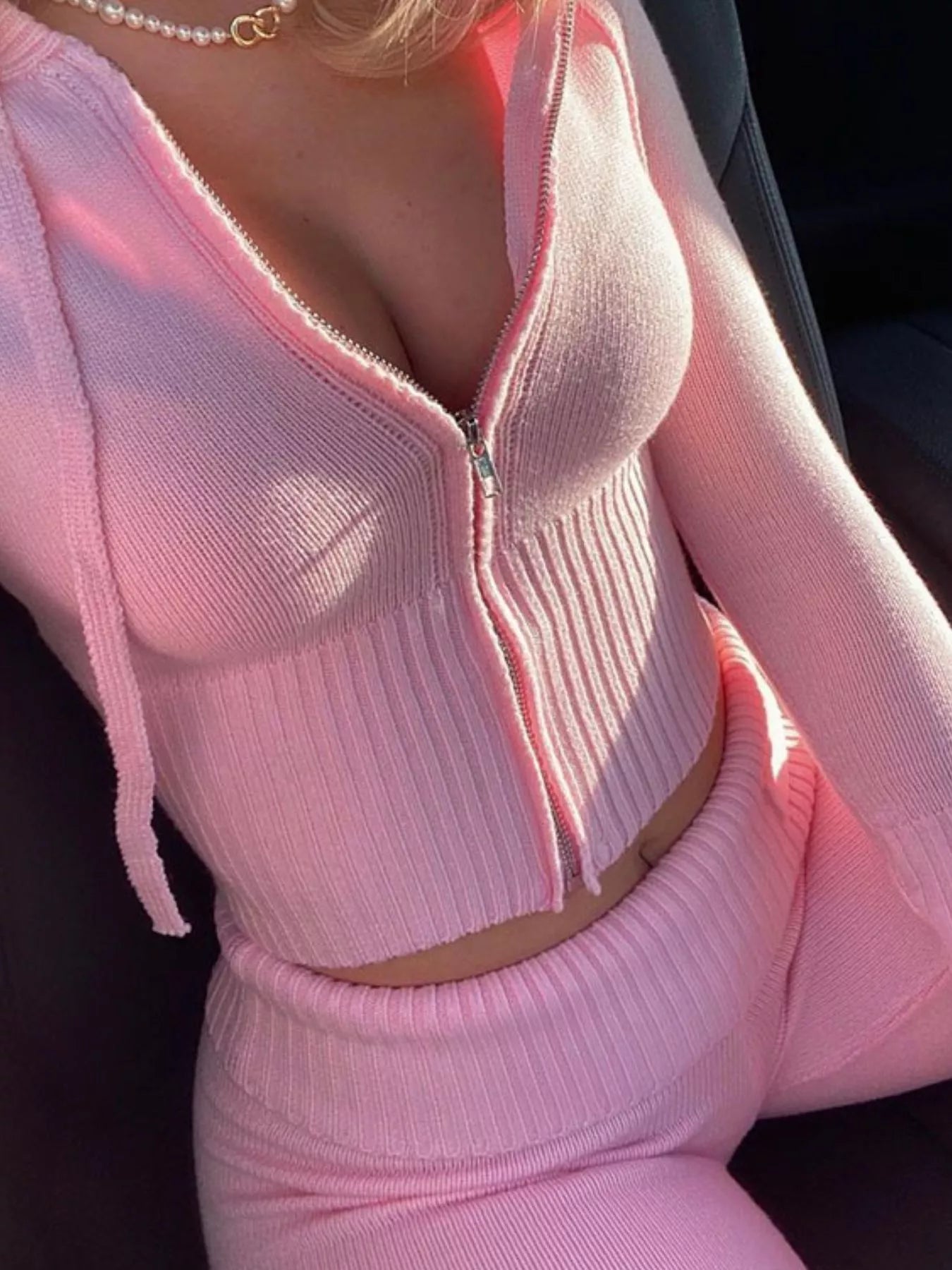 Close up of pink ribbed zip up hooded cardigan showing front zipper detail