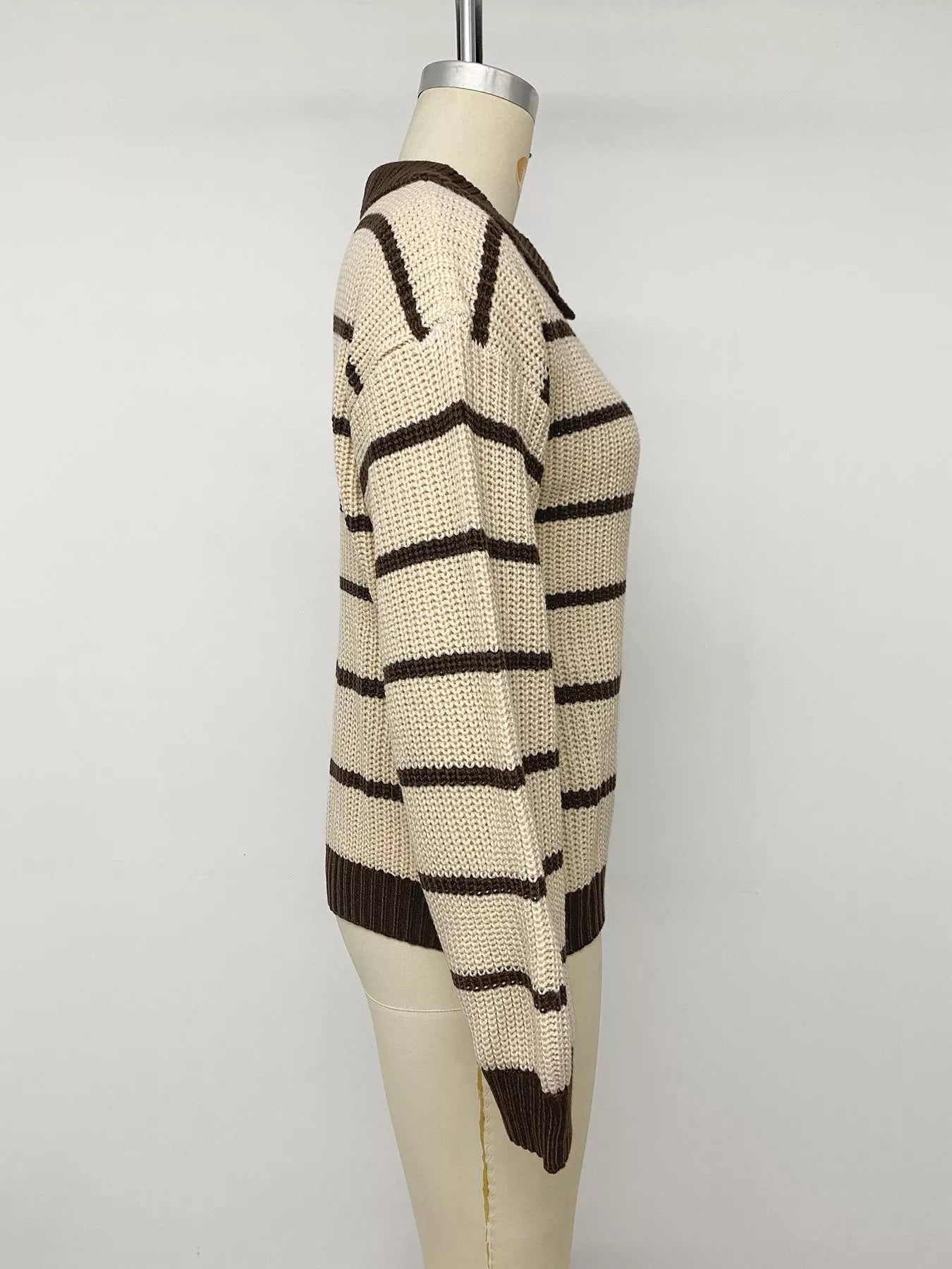 Side view on a mannequin of a cream and brown striped knit polo sweater.
