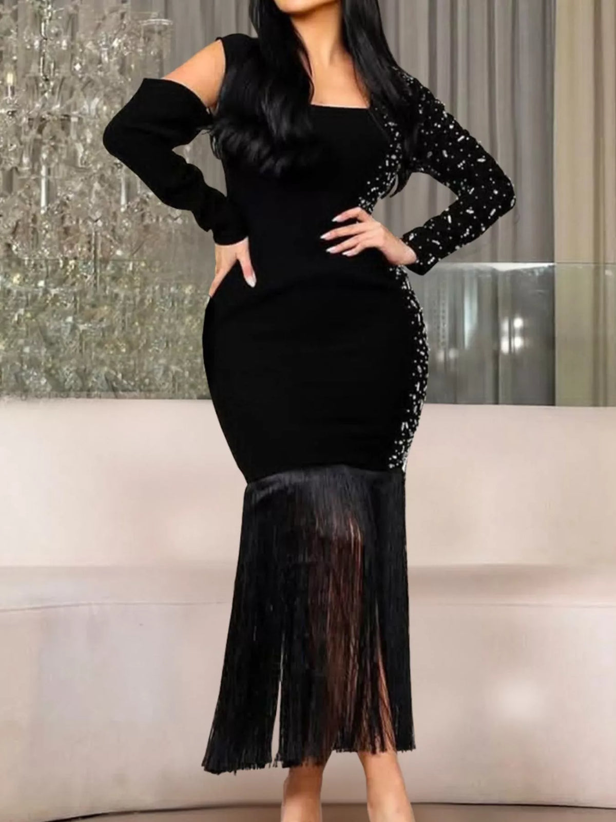 Black asymmetrical dress with rhinestone sleeve and fringe hem worn front view
