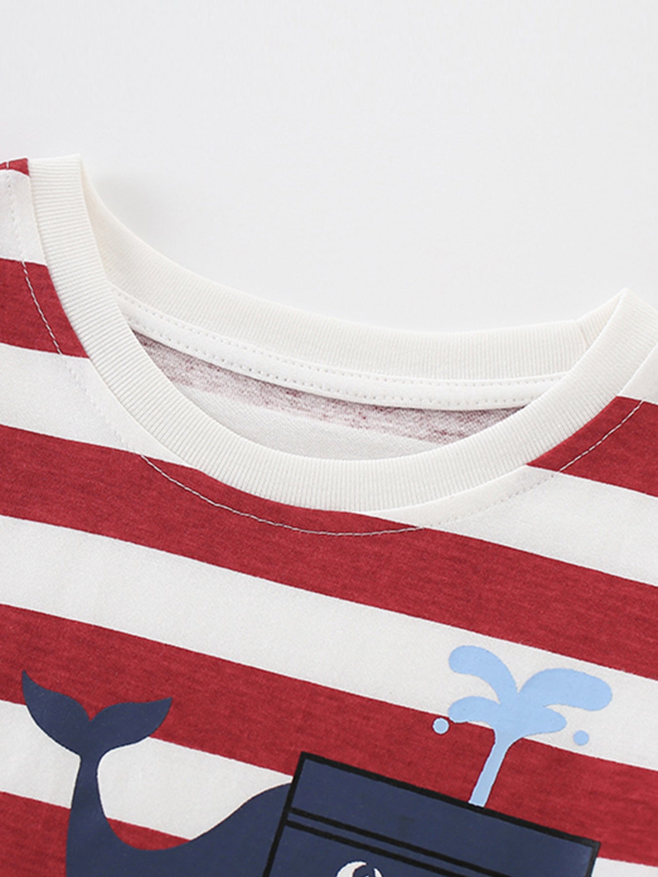 Close-up of the white crew neckline and stitching on the red striped children's t-shirt