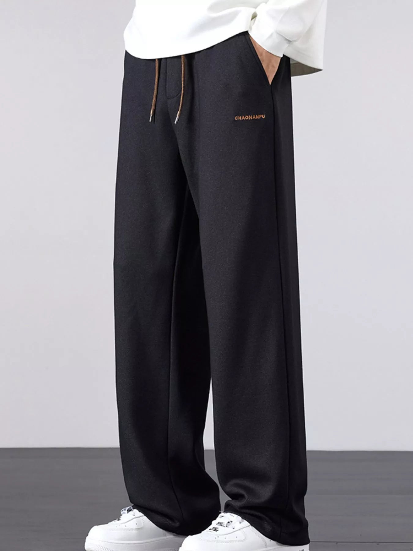 Men's navy loose fit casual pants with a drawstring waist and pockets.