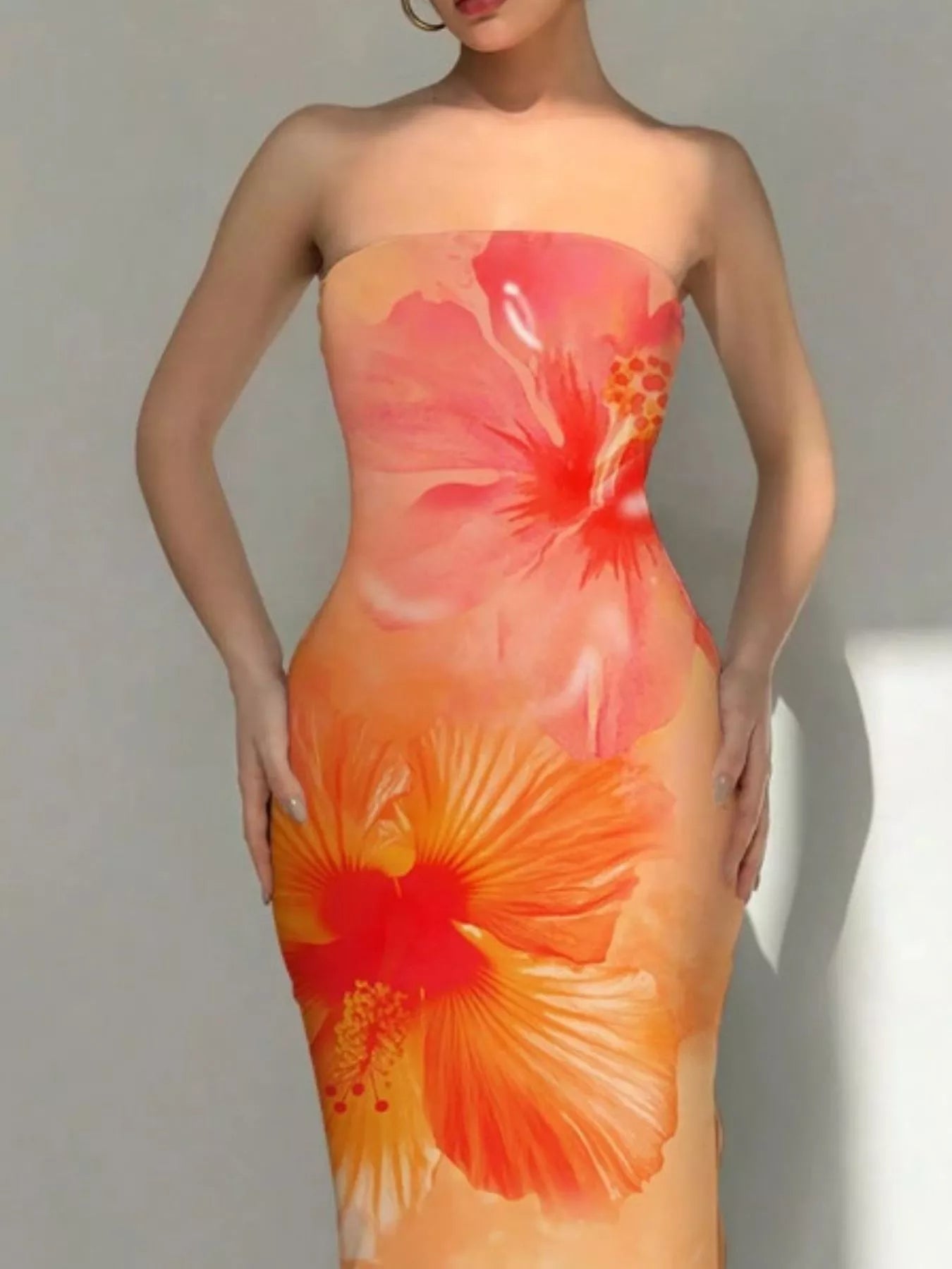 Close view of tangerine tropical flower print bodycon tube dress showing large hibiscus flowers