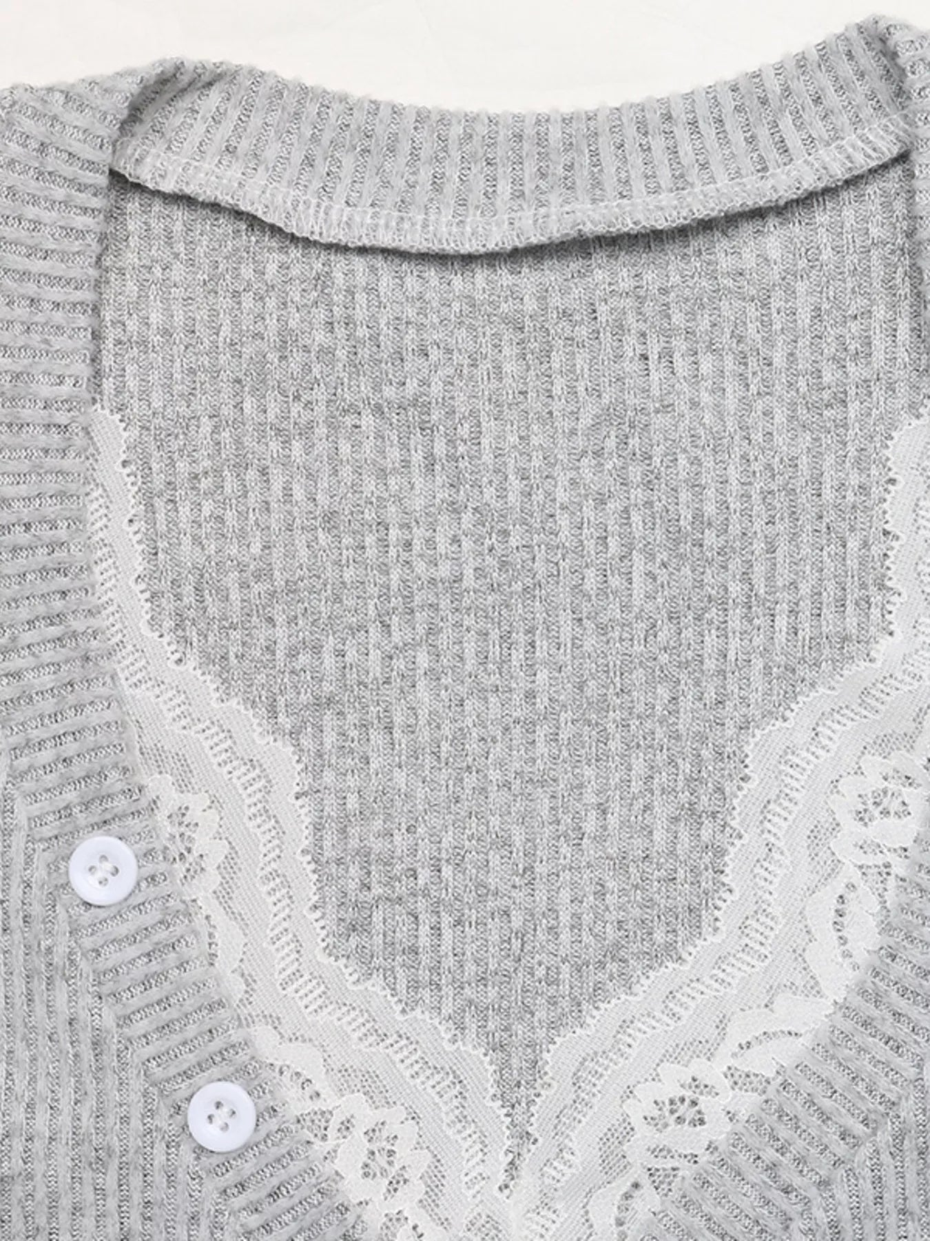 Close-up detail of a light gray ribbed Henley top with lace-trimmed edges and white buttons