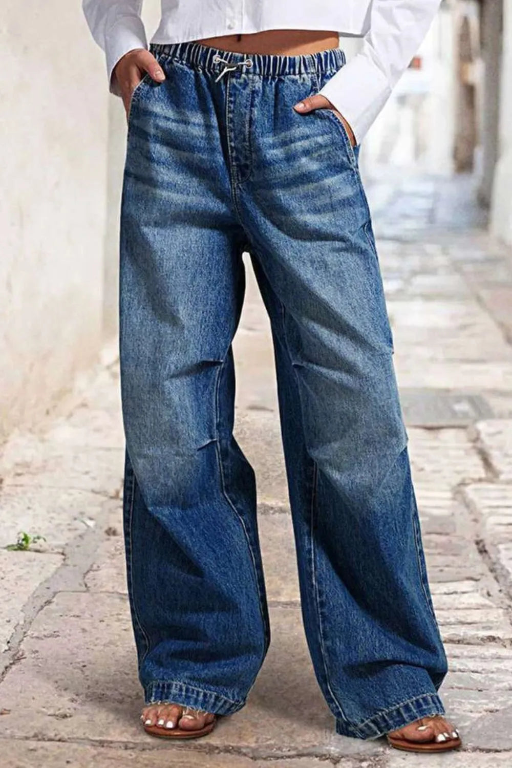 Women's wide-leg jeans with shirred detailing, a drawstring waist, and pockets.