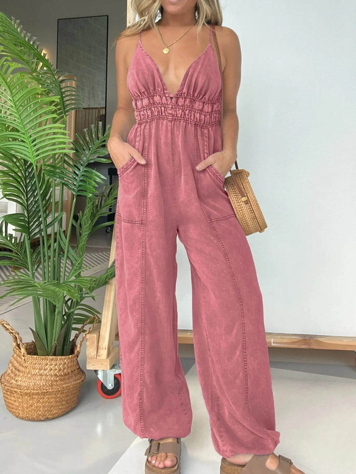 Women's smocked wide-leg jumpsuit with spaghetti straps and pockets.