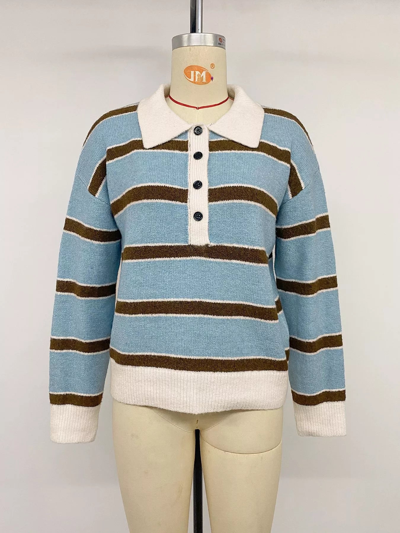 Front view of striped blue polo sweater on a mannequin, with cream collar and hem.