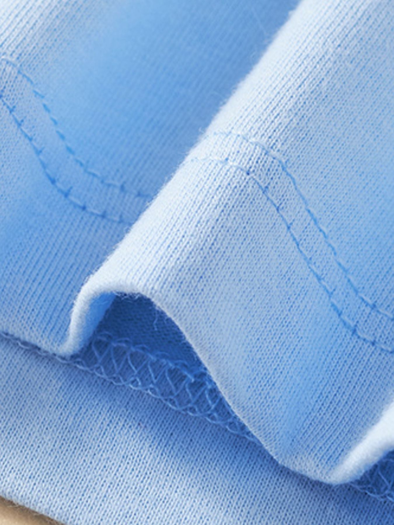 Close-up of the pastel blue sleeve hem showing fine stitching and soft fabric texture