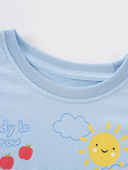 Close-up detail of the light blue round neckline, smiling sun and red apples on children's T-shirt