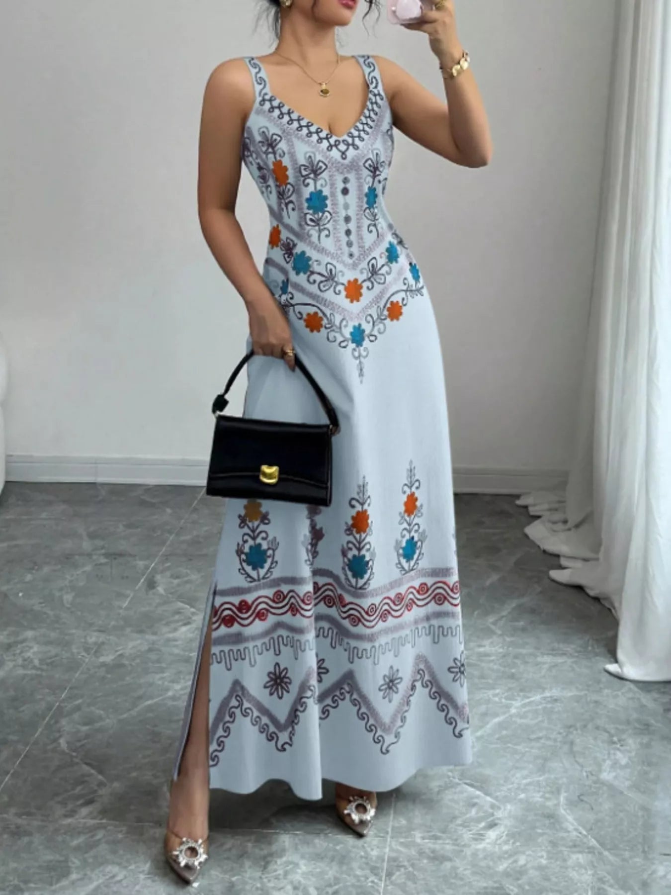 Light blue floral sleeveless maxi dress with side slit shown from the front on model