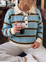 Seated front view of light blue and brown striped polo sweater with cream collar.