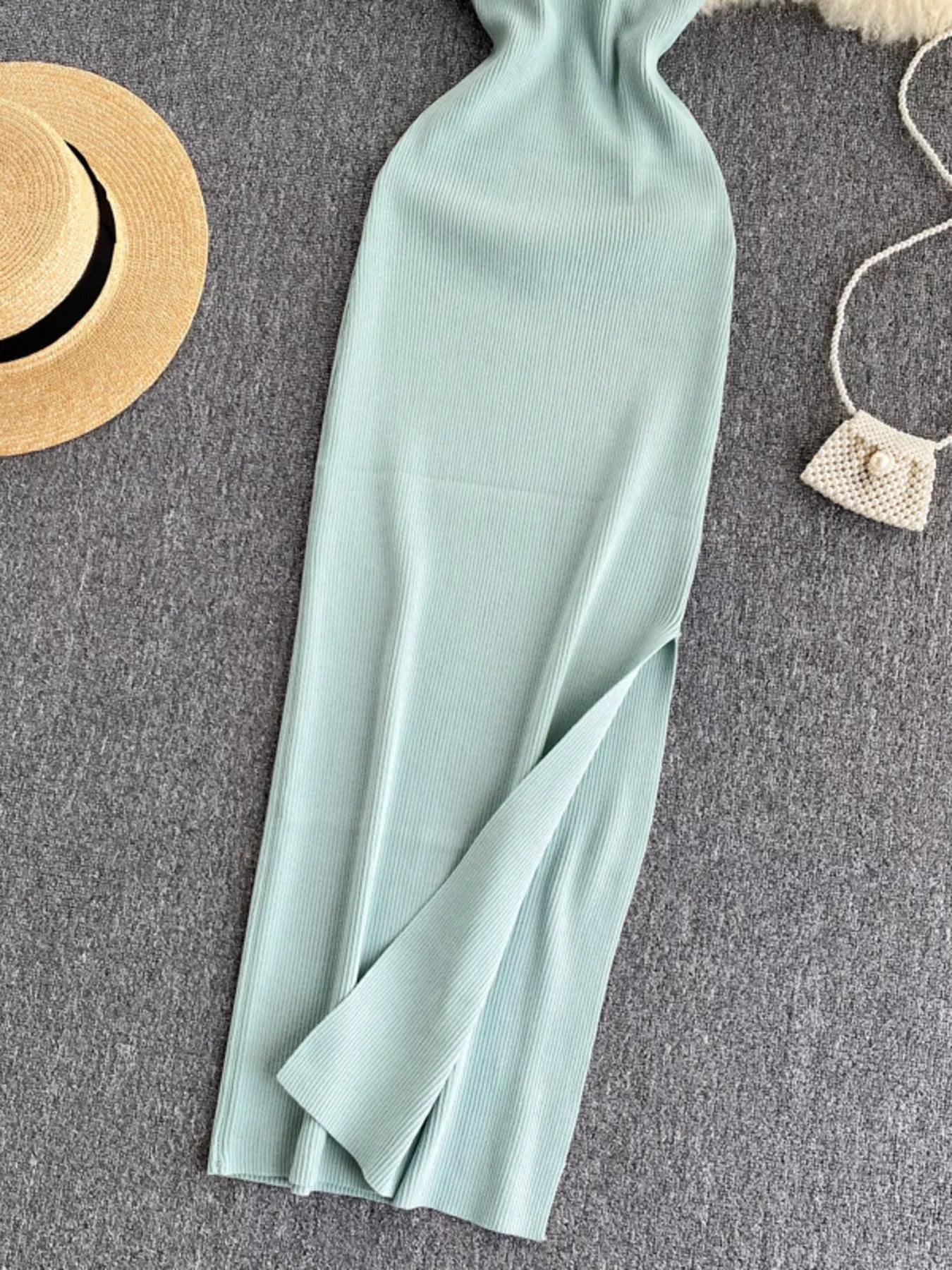 Lower skirt of mint ribbed knit midi dress showing side slit detail